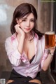 A woman in a pink shirt holding a glass of beer.