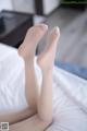A woman's legs are shown on a bed.
