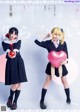 A couple of girls in school uniforms holding a heart shaped balloon.